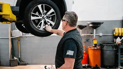 Servicemitarbeitercheckt Felge eines Autos